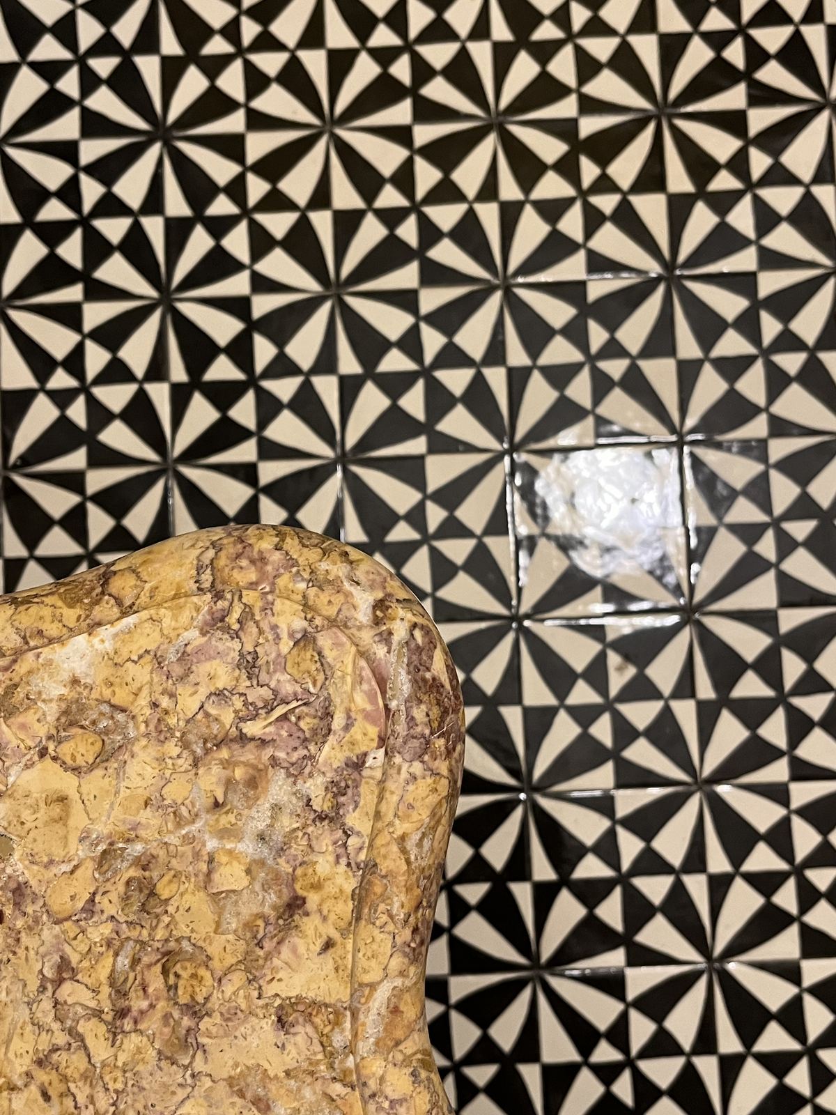 Stone sample on black and white star-pattern tile