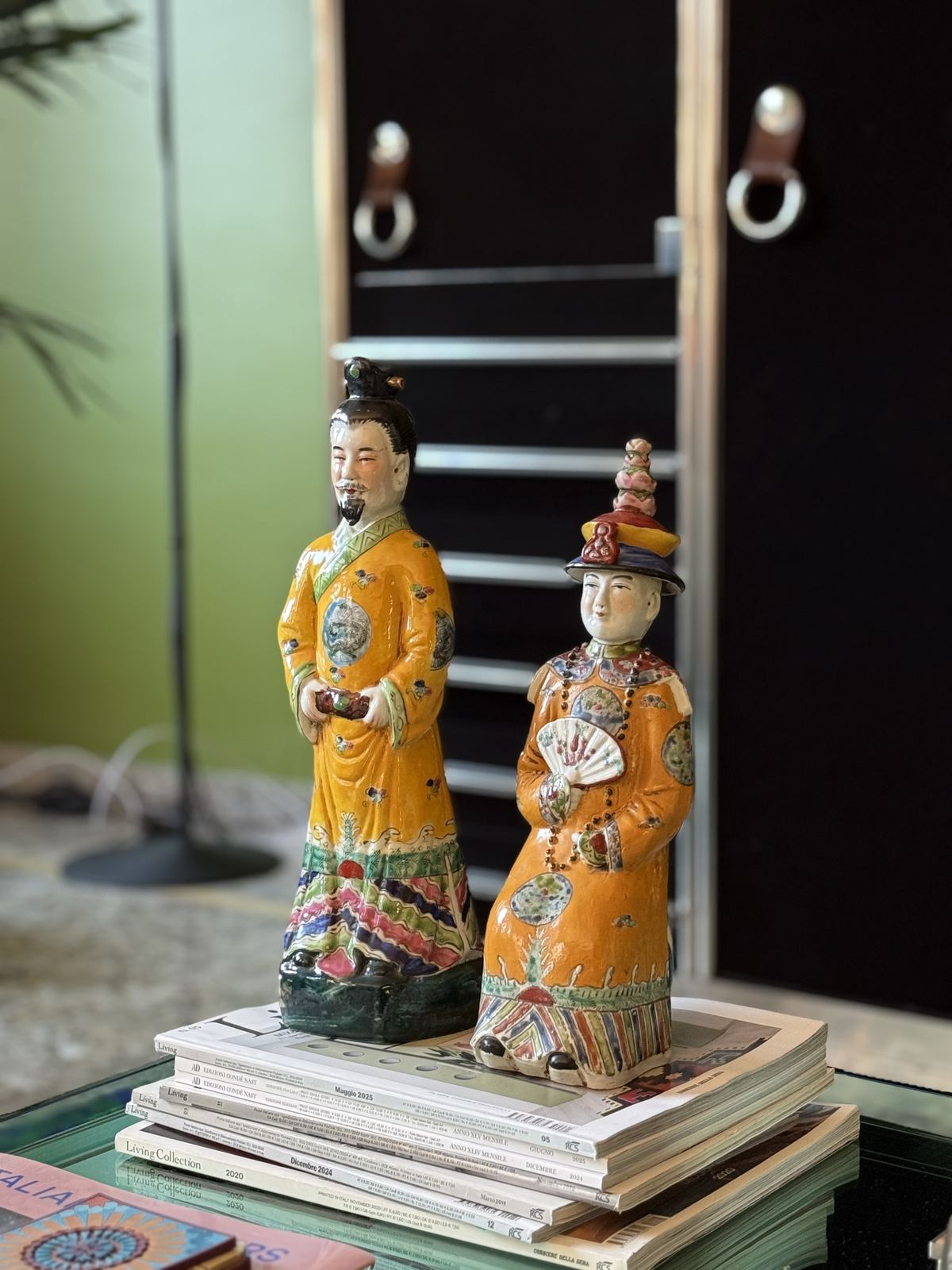 Pair of glazed ceramic figures standing on books