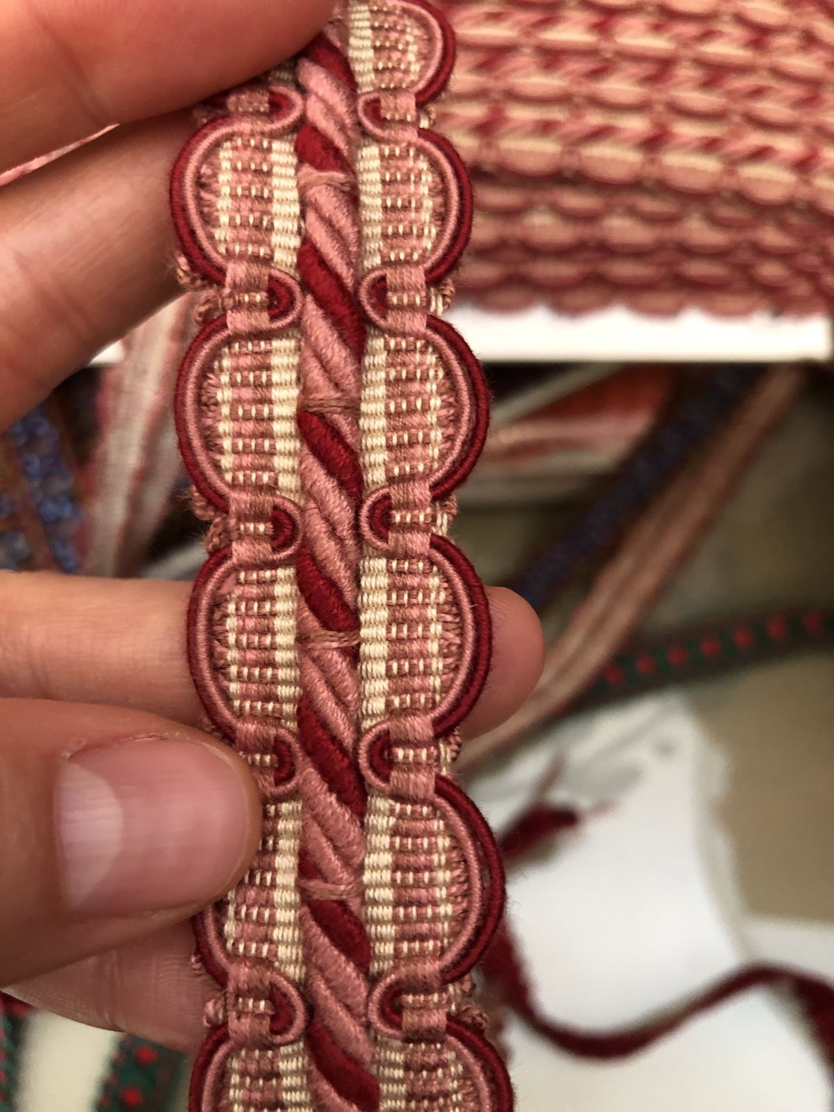 Braided red passementerie trim held in a hand