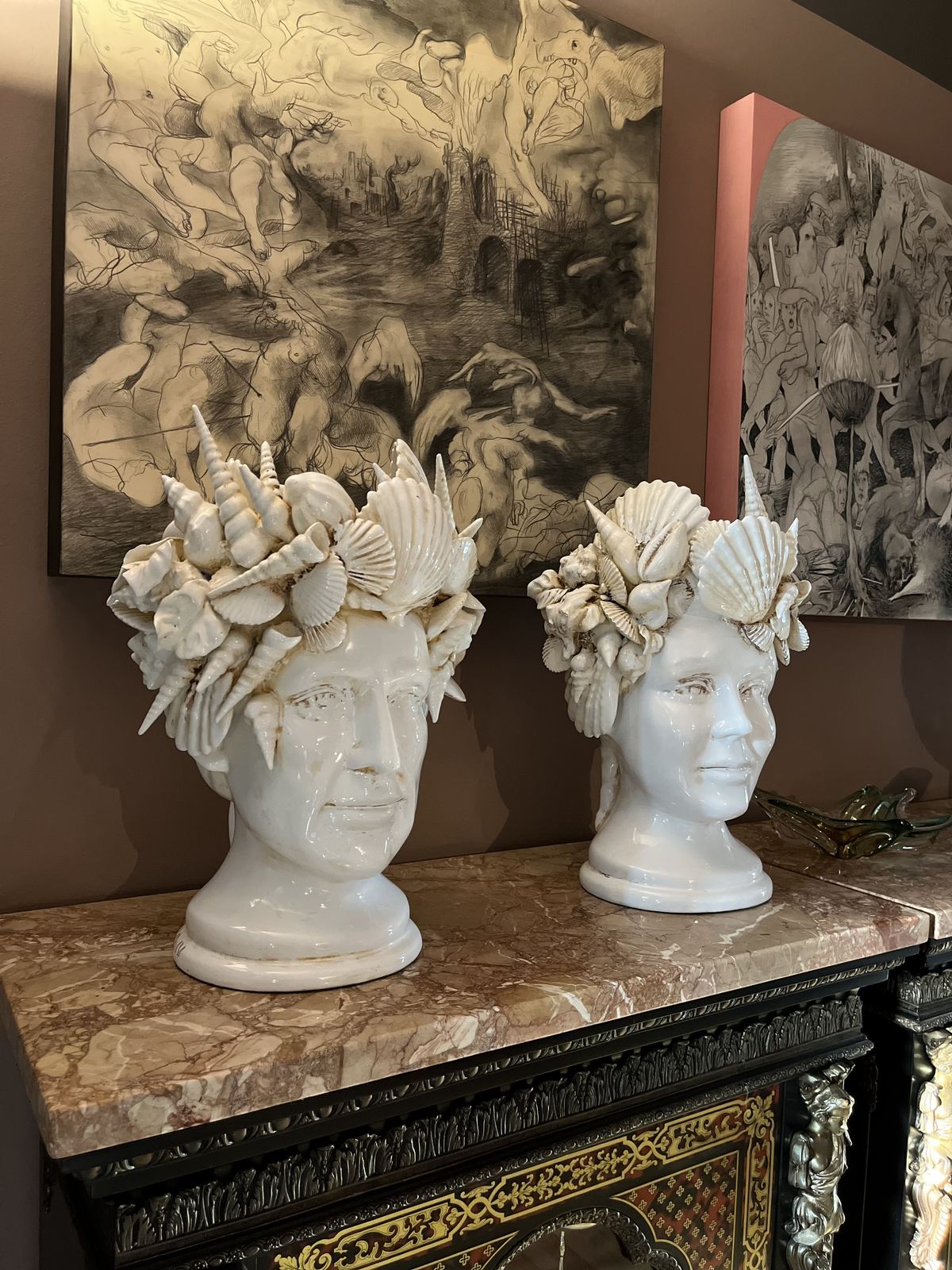 Two white sculptural heads on a marble top