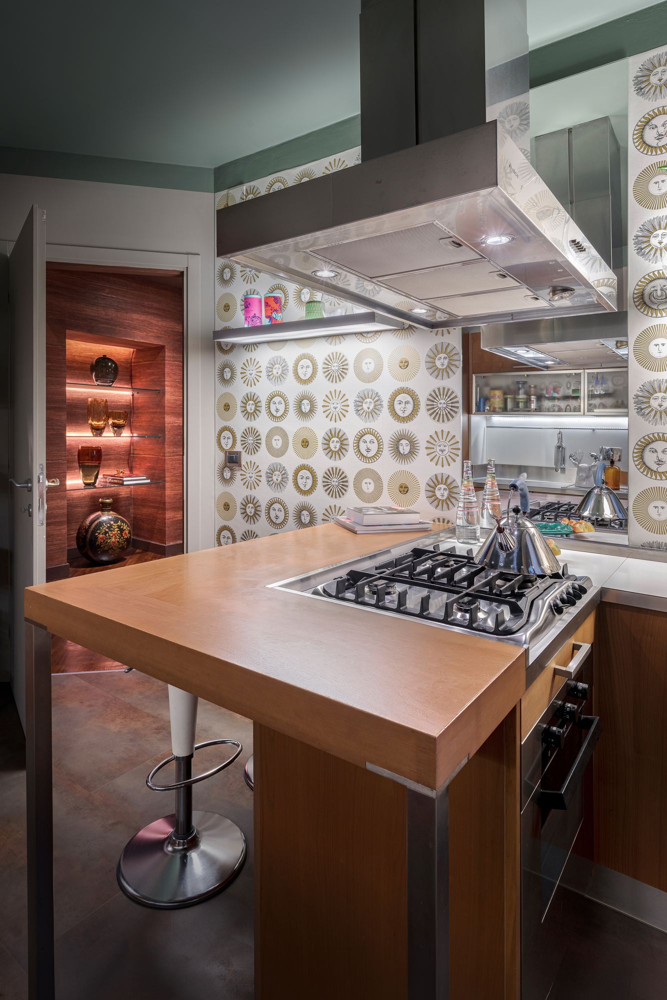 Kitchen with a wooden island and a steel hood