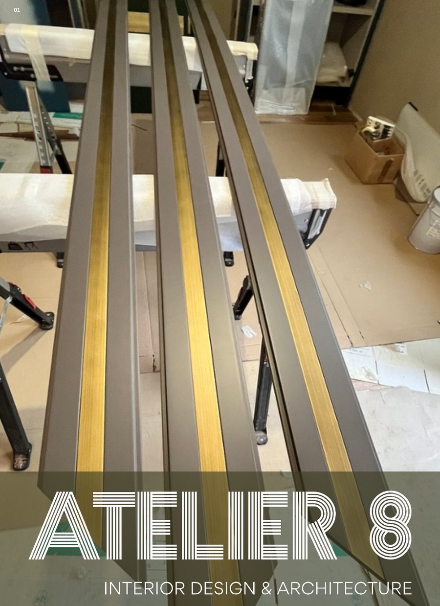 Brass-inlaid joinery profiles in the workshop, with the Atelier 8 logo